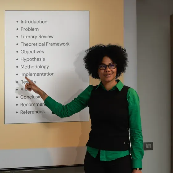 A teacher pointing to a whiteboard