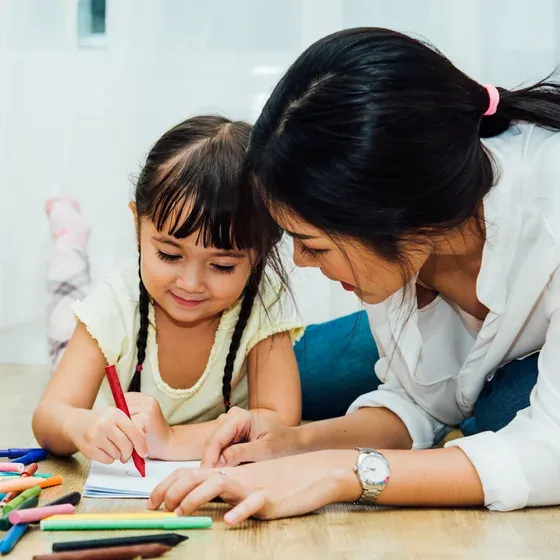 An adult and a child drawing together